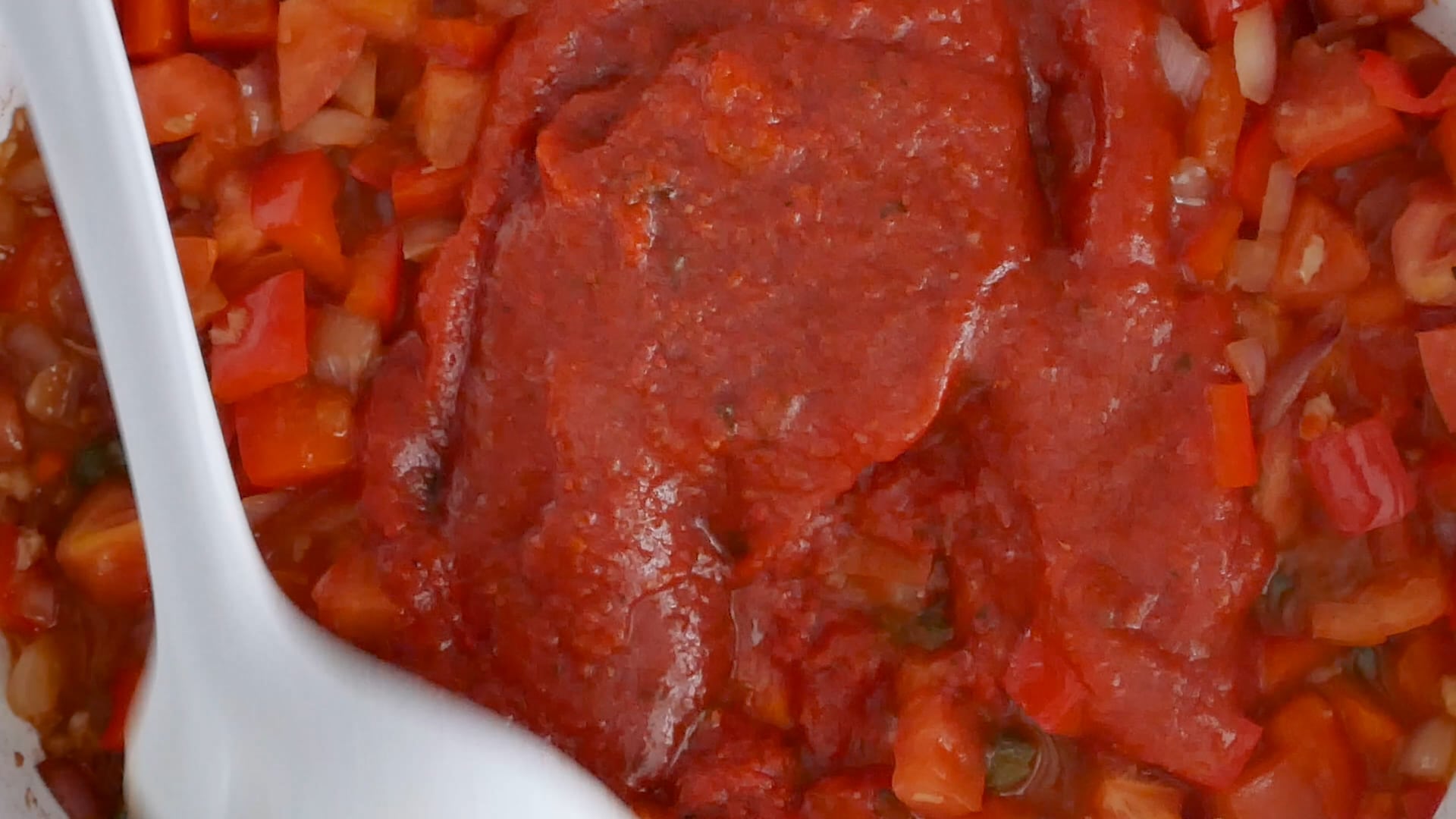 Adding tomato sauce to the skillet