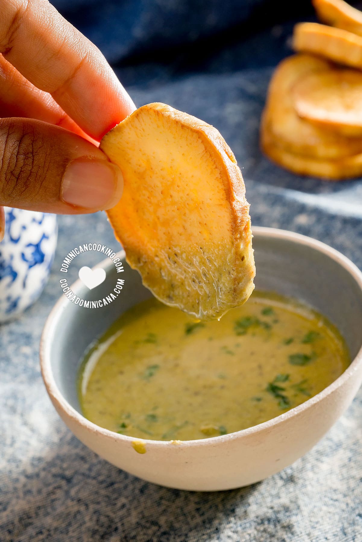 Hand holding a batata fry in dip