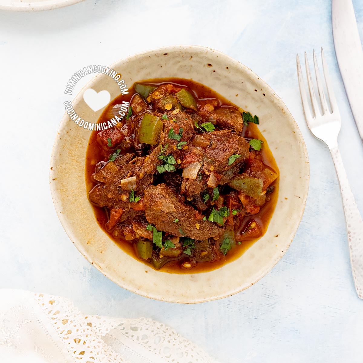 Carne de Res Guisada (Dominican Braised Beef) served next to rice, tostones, and salad