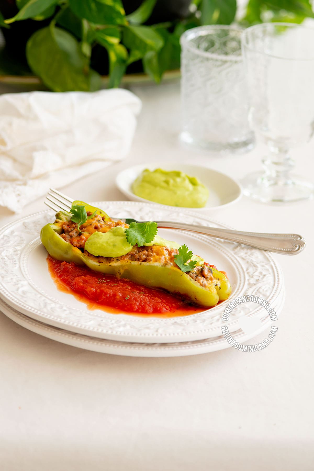 Plate with pepper boat on tomato sauce and bowl with avocado sauce