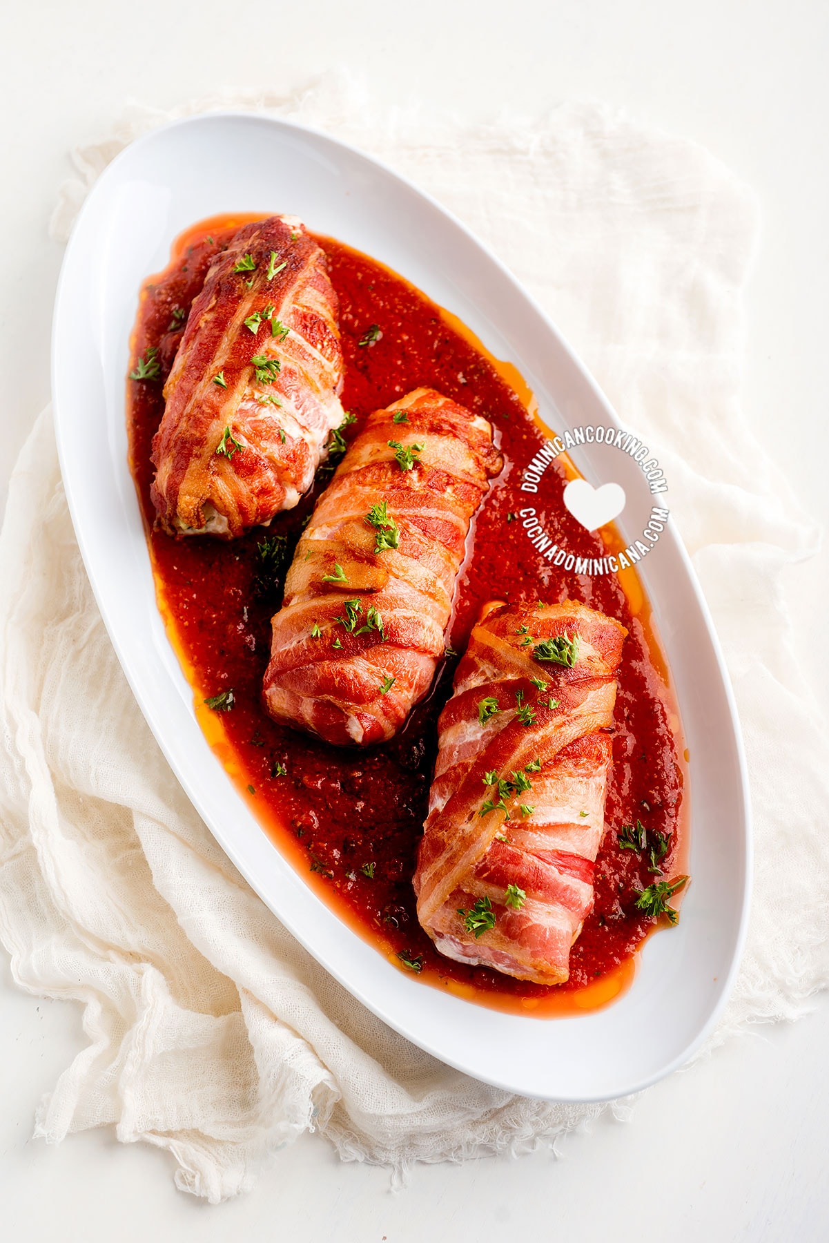 Tray with 3 Bacon-Wrapped Chicken Rolls on Tomato Sauce