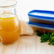 Jar and cups of homemade chicken broth