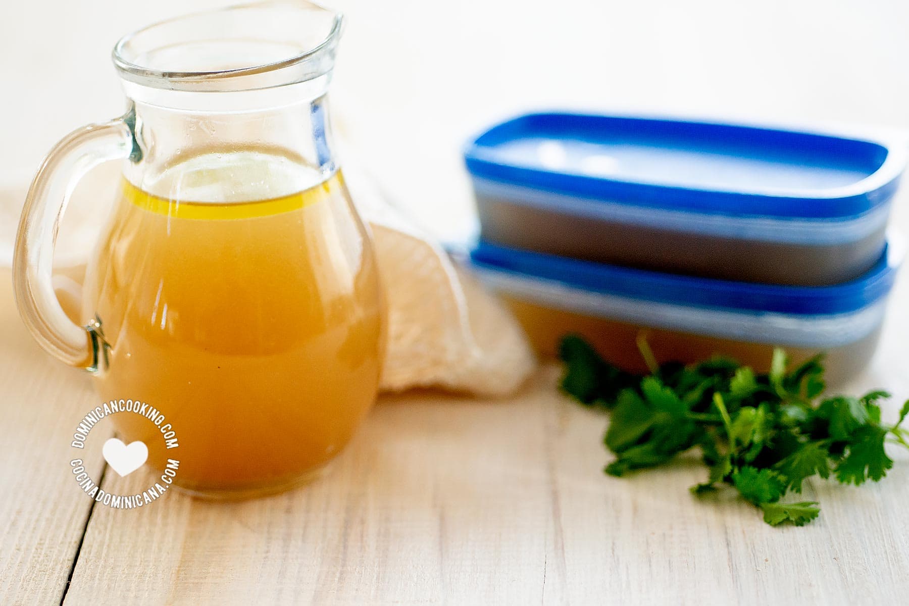 Jar and cups of homemade chicken broth