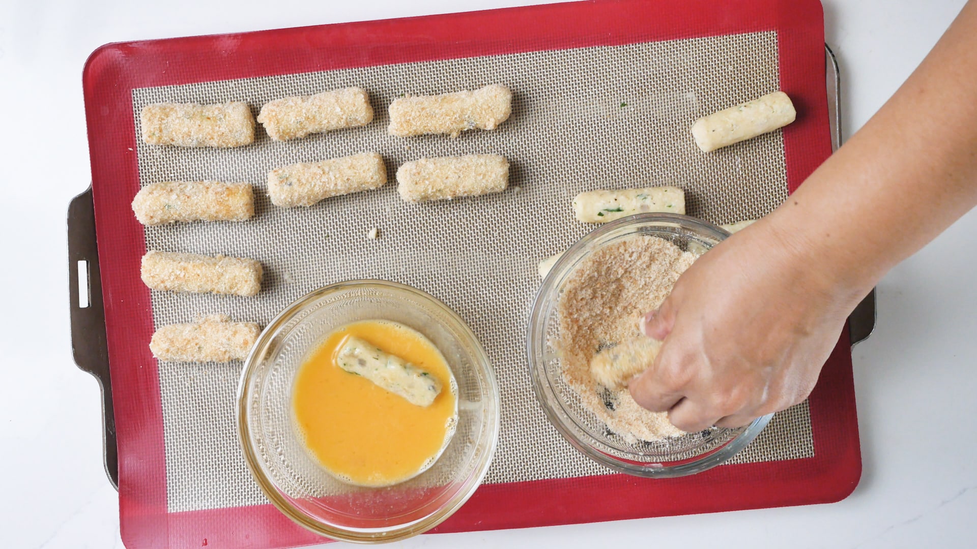 Dusting the croquettes in the breadcrumbs