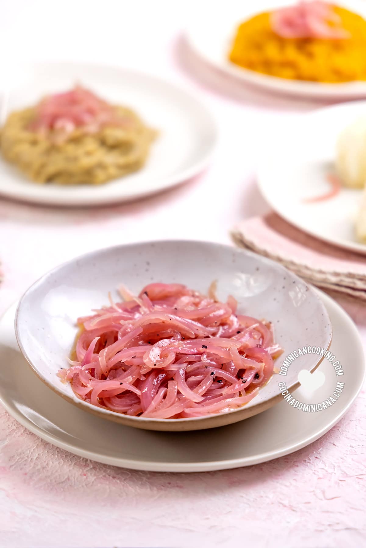 Dominican Sauteed Red Onions with Vinegar with dishes in the background