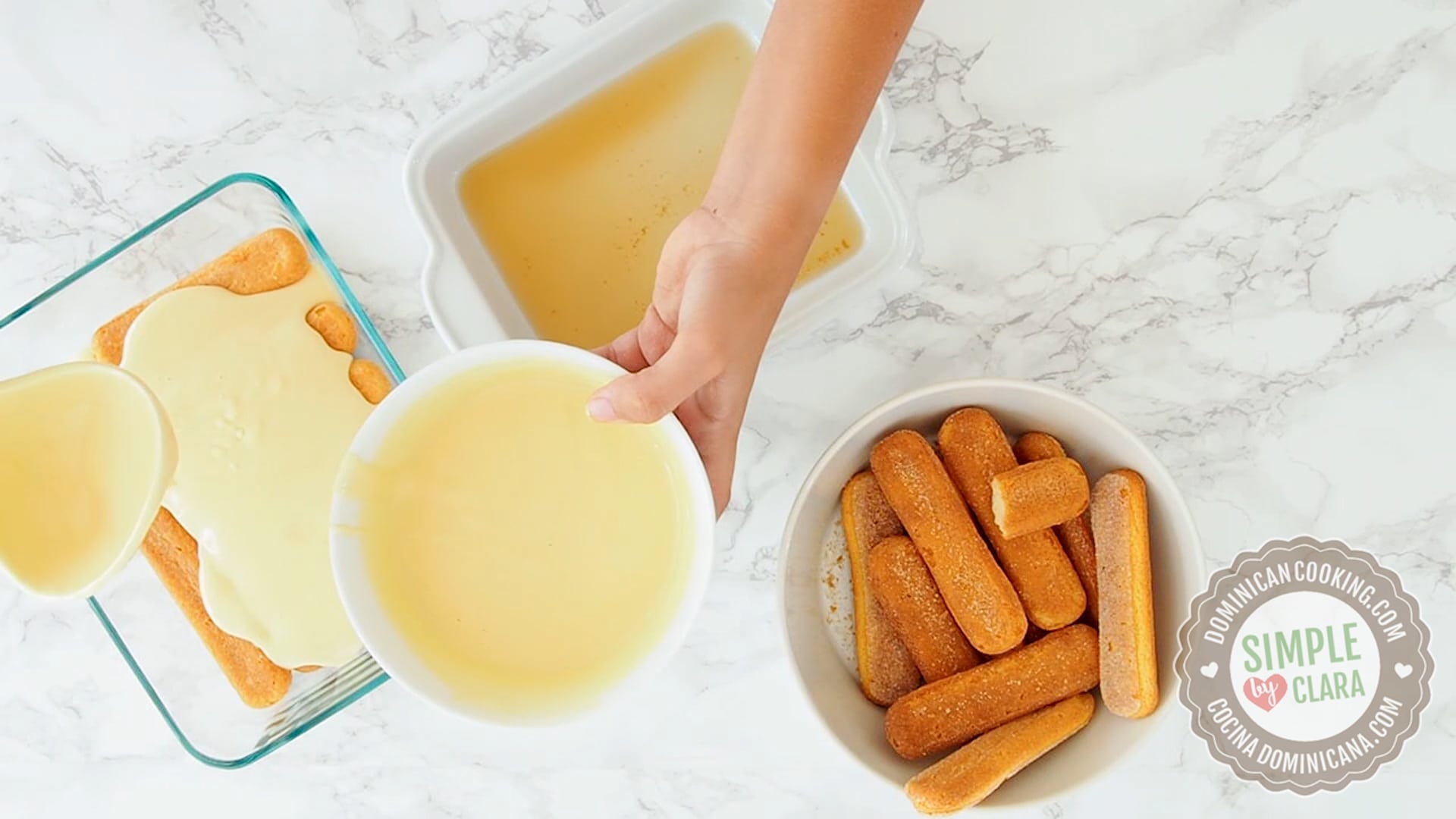 Pouring sweet sauce over ladyfingers