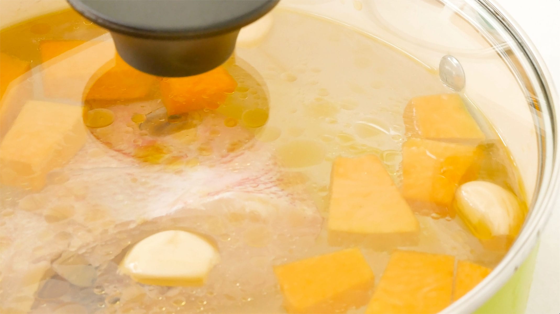 Ingredients for fish soup boiling in a pot