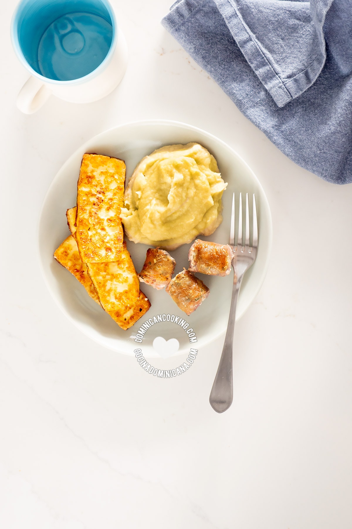 Dominican keto breakfast of fried cheese, egg and sausage with mash seen from above