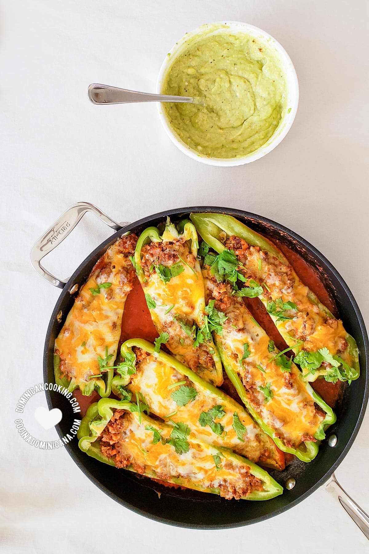 Pan with pepper boats on tomato sauce and bowl with avocado sauce