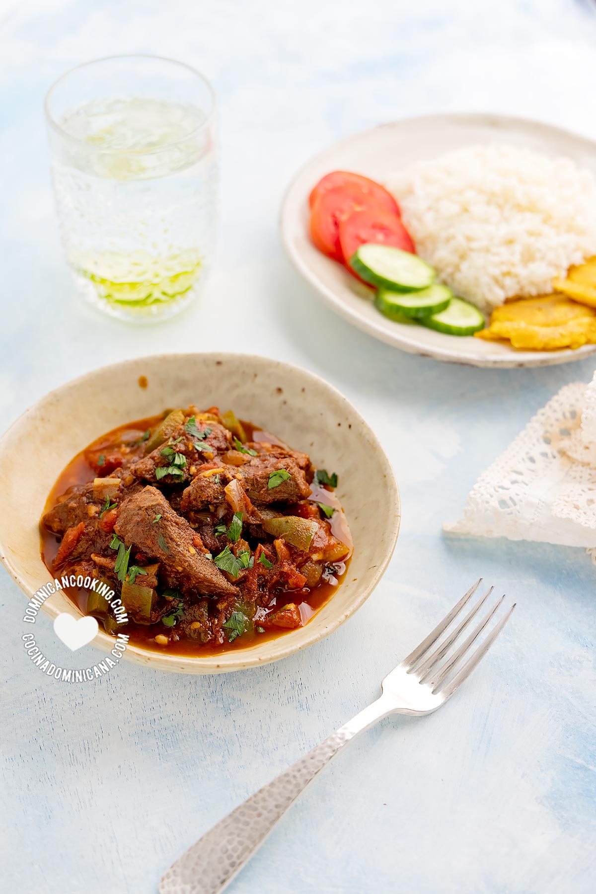 Carne de Res Guisada (Dominican Braised Beef) served next to rice, tostones, and salad