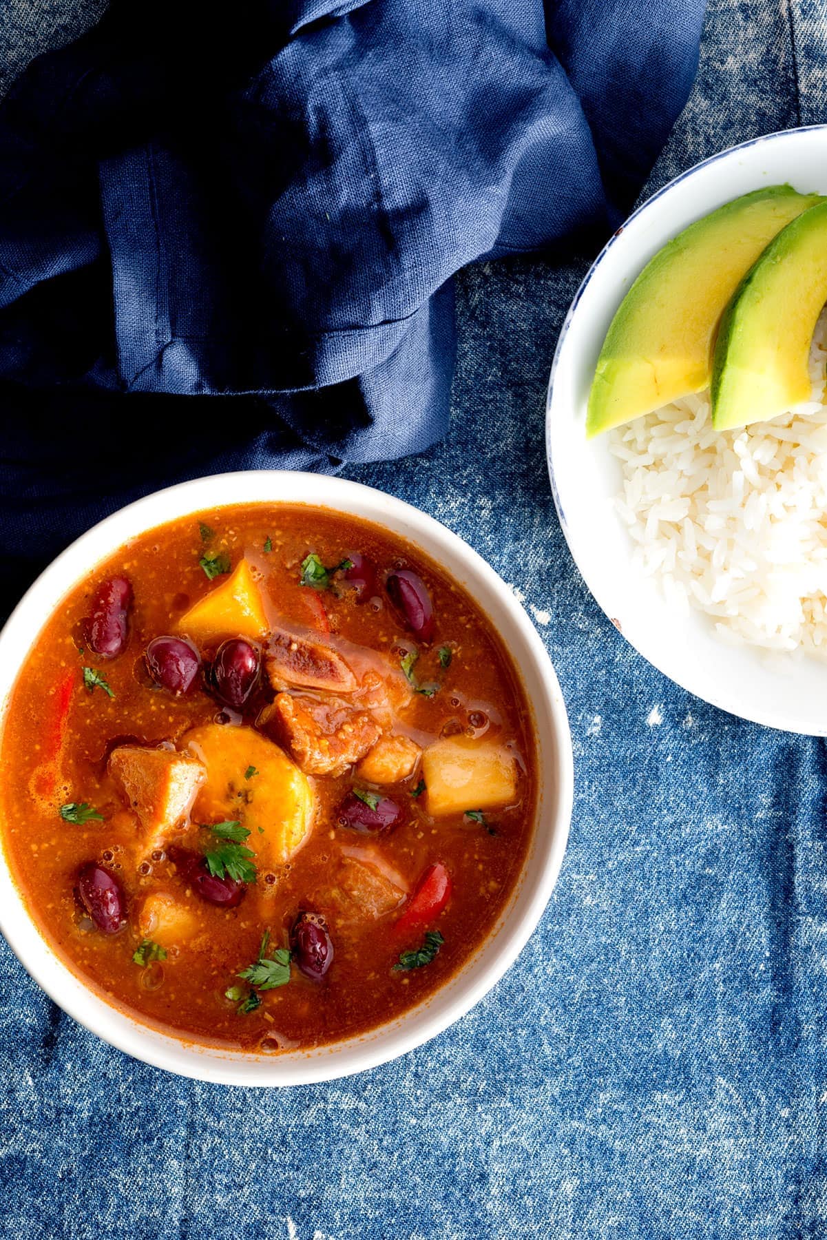 Bowl of Sancocho de Habichuelas or Sopión or Zambumbio (Sweet & Spicy Bean Stew) Served with Rice and Avocado Slices