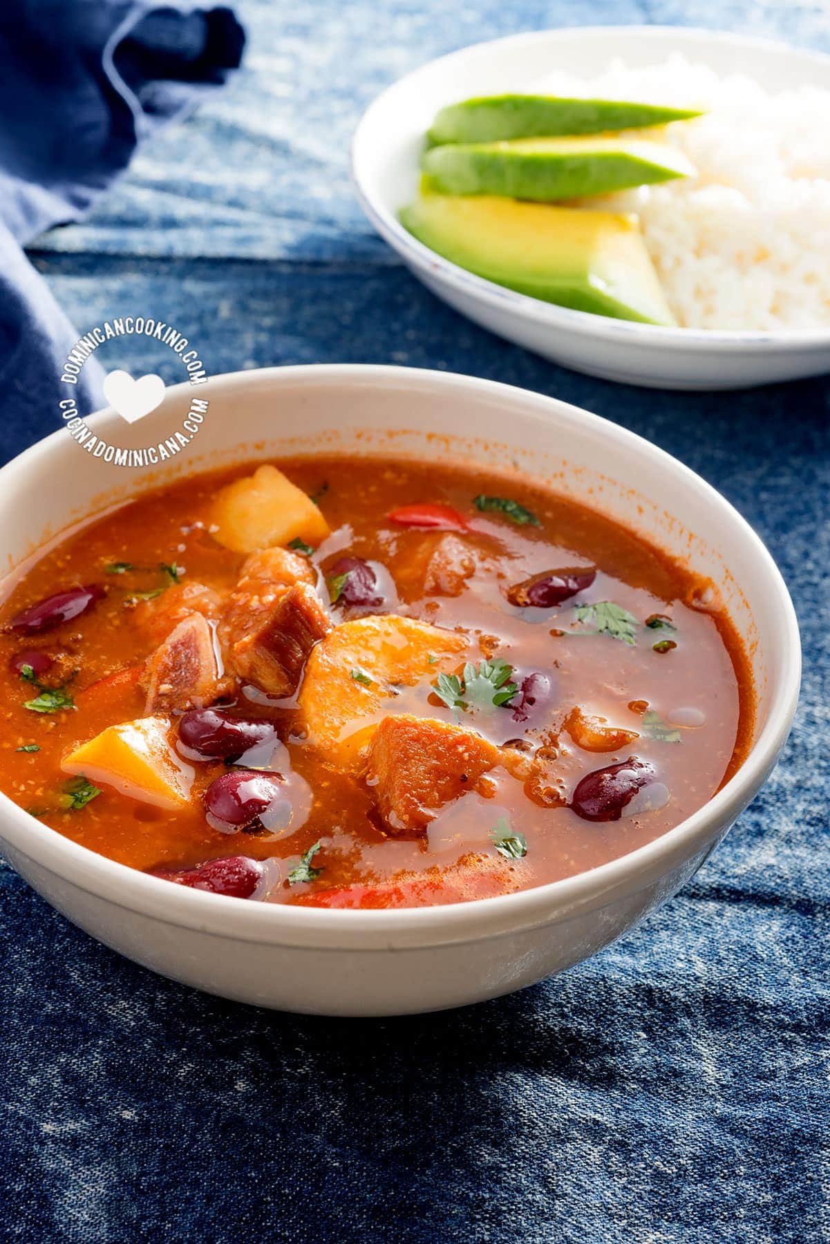 Bowl of Sancocho de Habichuelas or Sopión or Zambumbio (Sweet & Spicy Bean Stew) Served with Rice and Avocado Slices