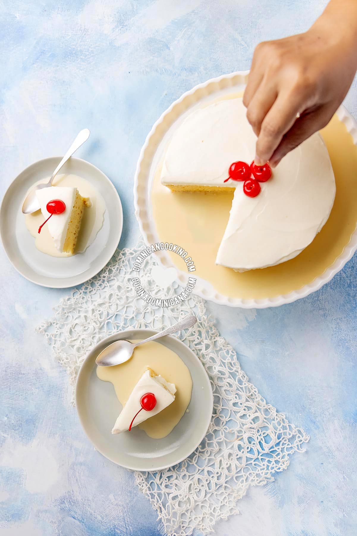 Hand putting cherry on Tres Leches (Three-Milk Cake)