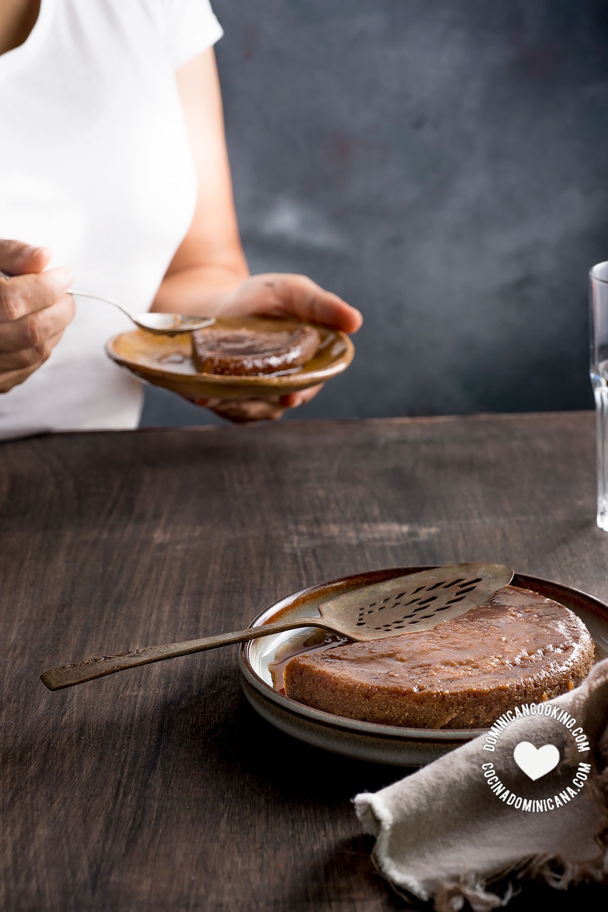 Cassava Flour (Tapioca) Pudding with woman in the background holding a slice